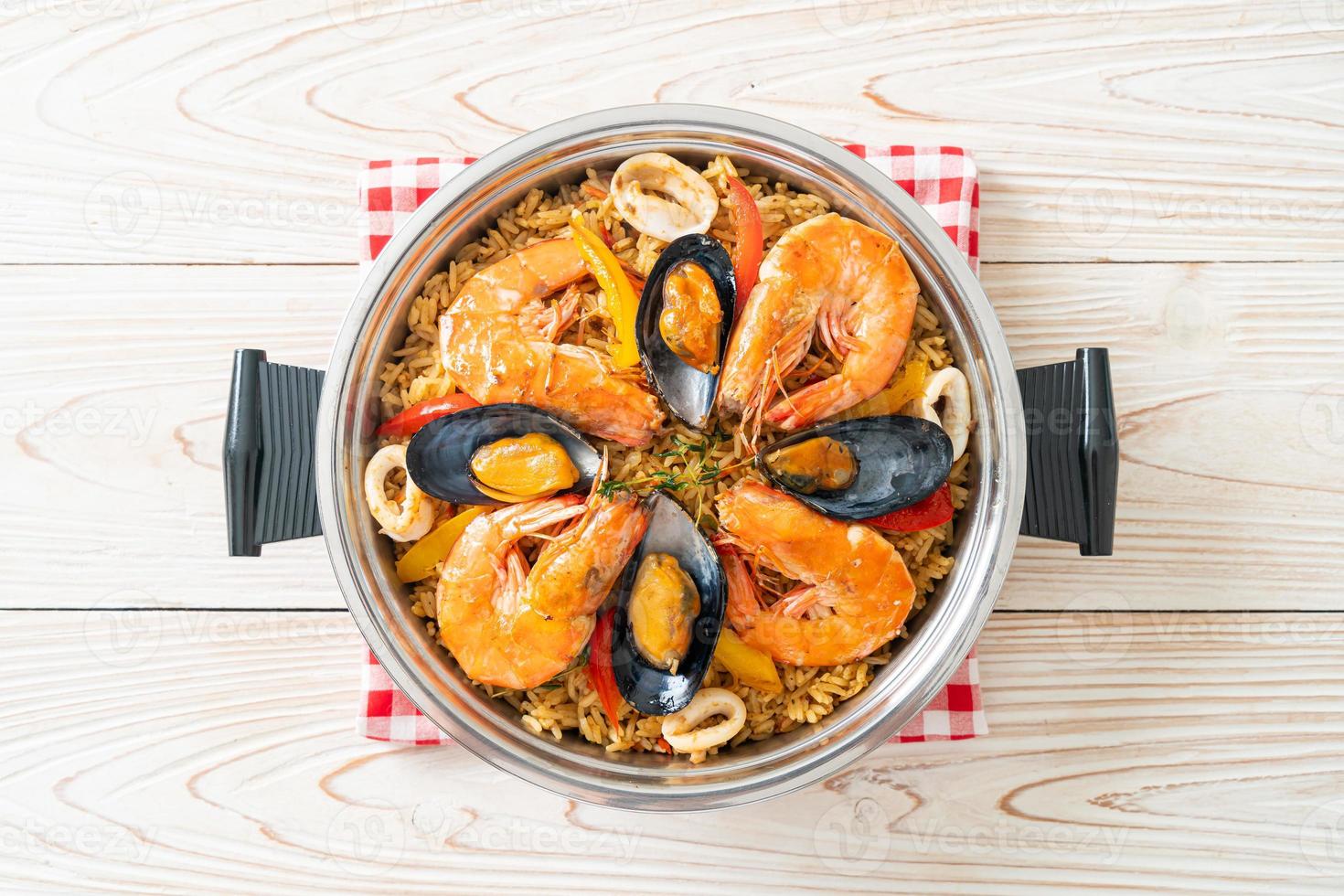 Meeresfrüchte-Paella mit Garnelen, Venusmuscheln, Miesmuscheln auf Safranreis foto