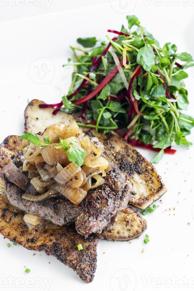 Rindersteak mit gegrillten Champignons und karamellisierten Zwiebeln Gourmetessen auf weißem Teller foto