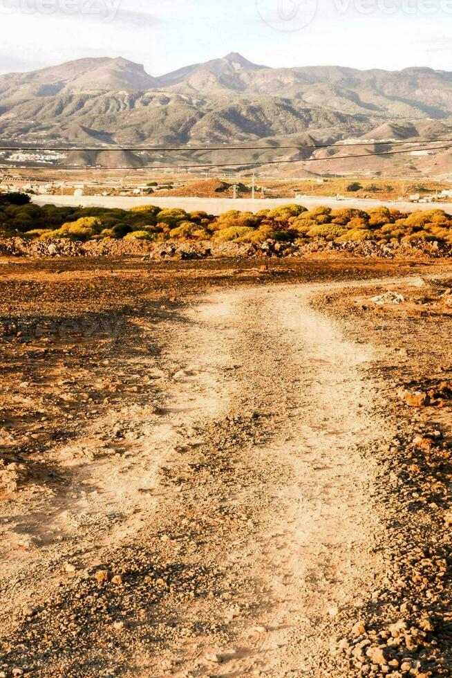 ein Schmutz Straße im das Mitte von ein Wüste mit Berge im das Hintergrund foto