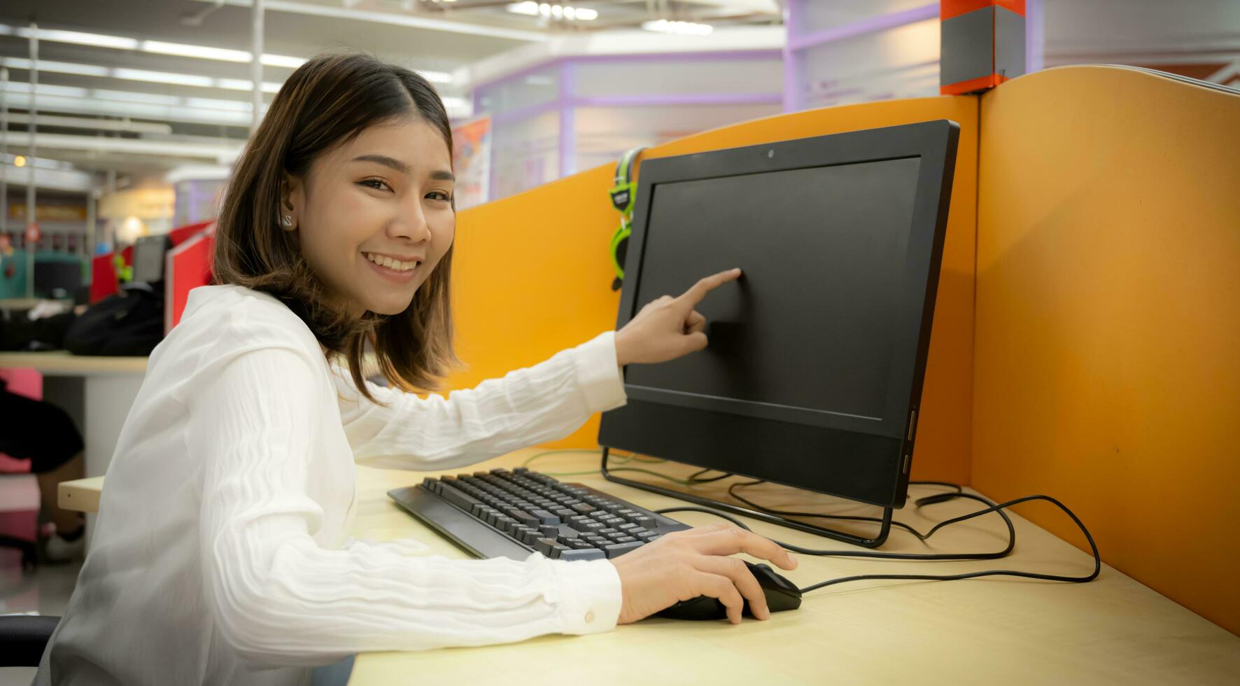 schön asiatisch Büro Frau demonstriert Computer Performance im korporativ Büro. foto