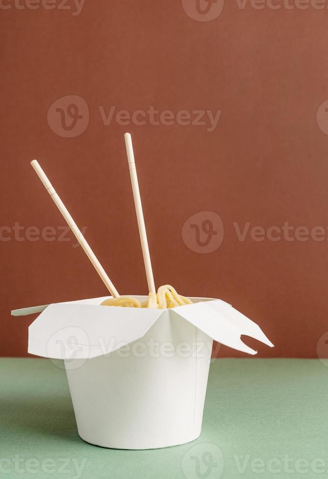 geöffnete Wok-Papierbox mit Nudeln und Stäbchen für Mock-up-Design foto
