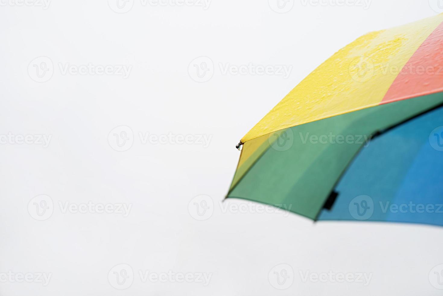 Nahaufnahme eines bunten Regenschirmteils mit Regentropfen foto