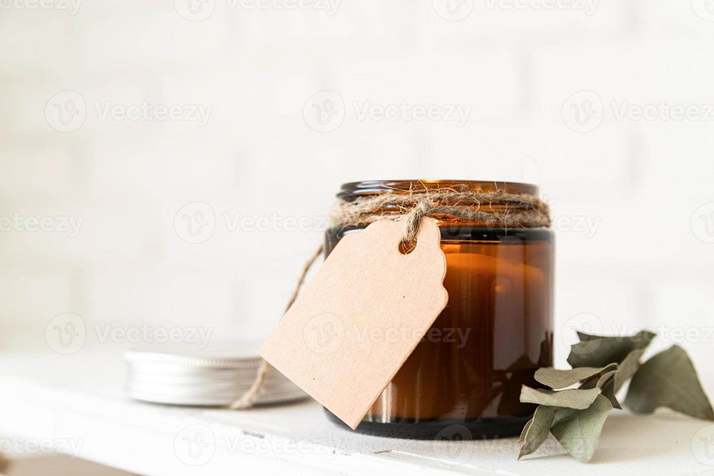 schöne brennende Kerze mit Eukalyptusblättern und Bastelpreisschild foto