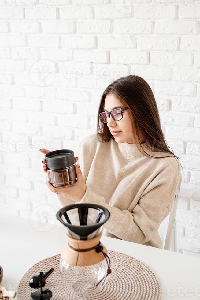 Frau, die Kaffee in der Kaffeekanne brüht foto