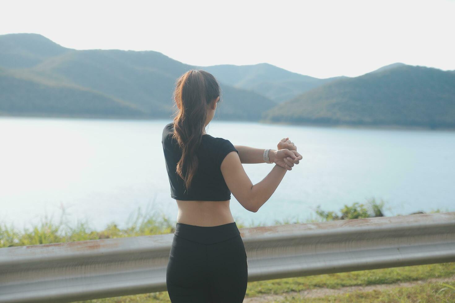 jung schön asiatisch Frau im Sport Outfits tun Dehnen Vor trainieren draussen im das Park im das Morgen zu erhalten ein gesund Lebensstil. gesund jung Frau Erwärmen oben draußen. foto