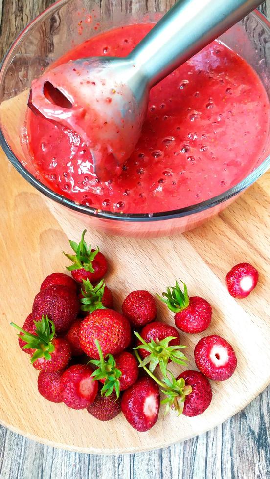 Erdbeeren mit einem elektrischen Mixer verarbeiten foto