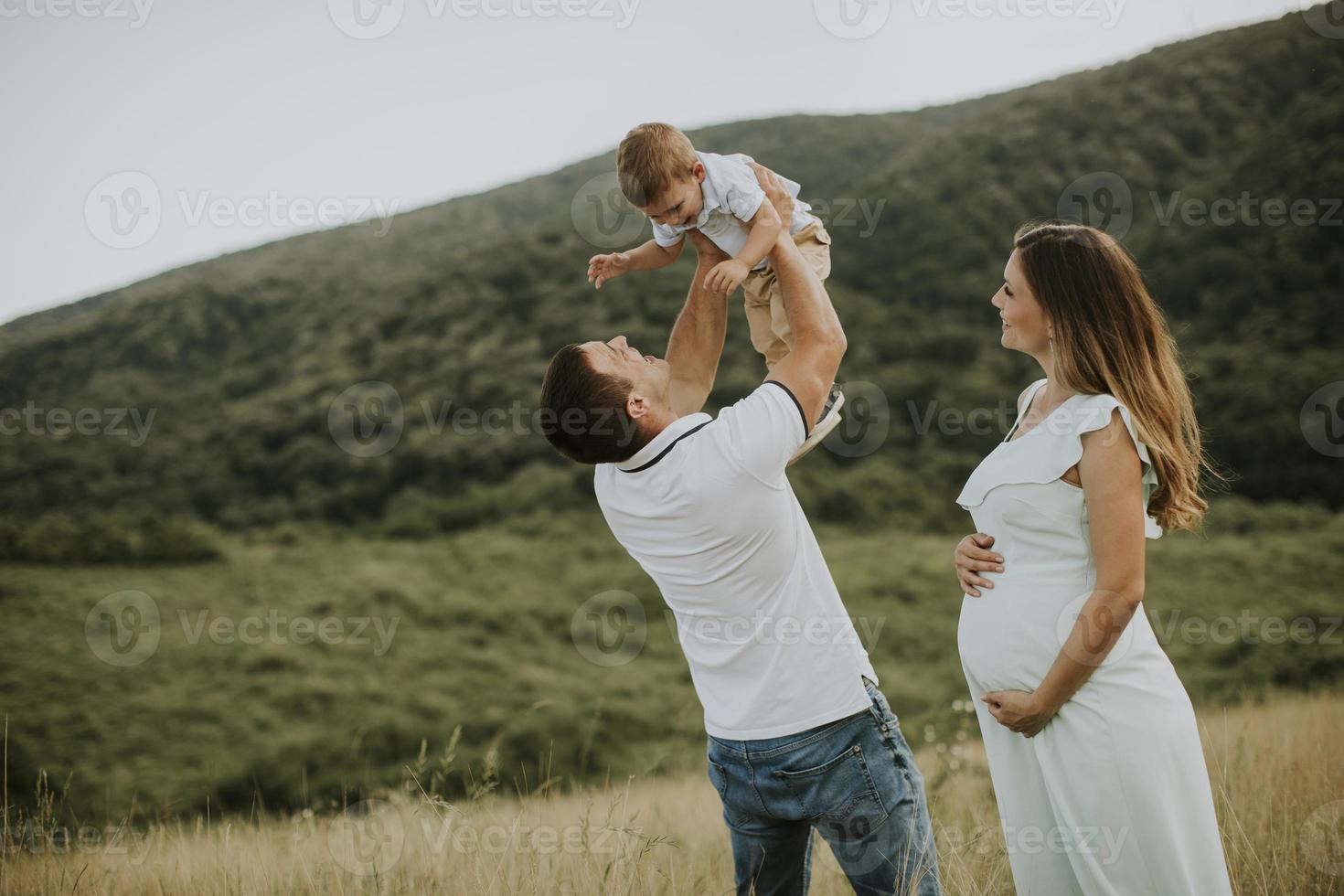 junge Familie mit süßem kleinen Jungen, der Spaß im Freien auf dem Feld hat foto