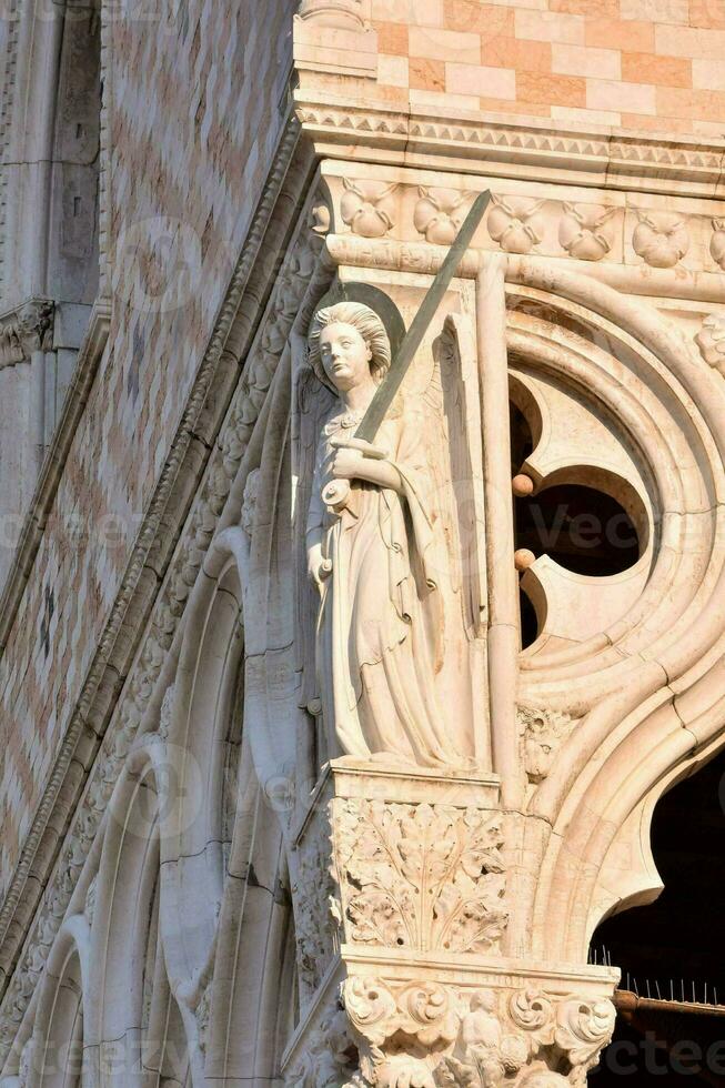 ein Statue von ein Engel auf das Ecke von ein Gebäude foto