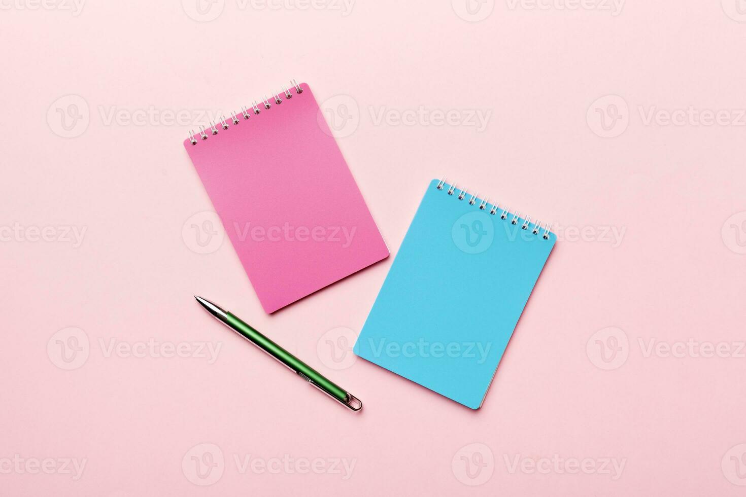 zwei Schule farbig Notizbuch auf ein Schreibtisch Hintergrund, Spiral- Kunst Notizblock auf ein Tabelle oben Aussicht foto
