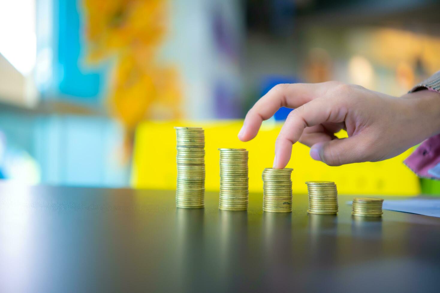 Geschäft Frau berühren das dritte Stapel von Münzen, Finanzen und Verwaltung Konzept, Konzept von Speichern Geld zum das Zukunft. foto