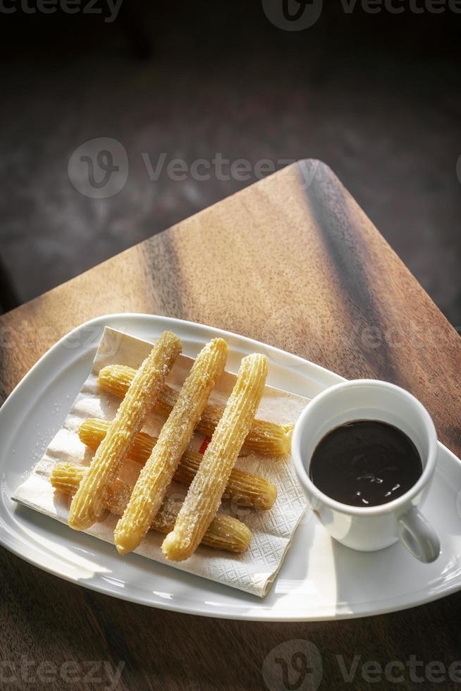 Churros con Schokolade traditionelles spanisches süßes Frühstück auf Holztisch foto