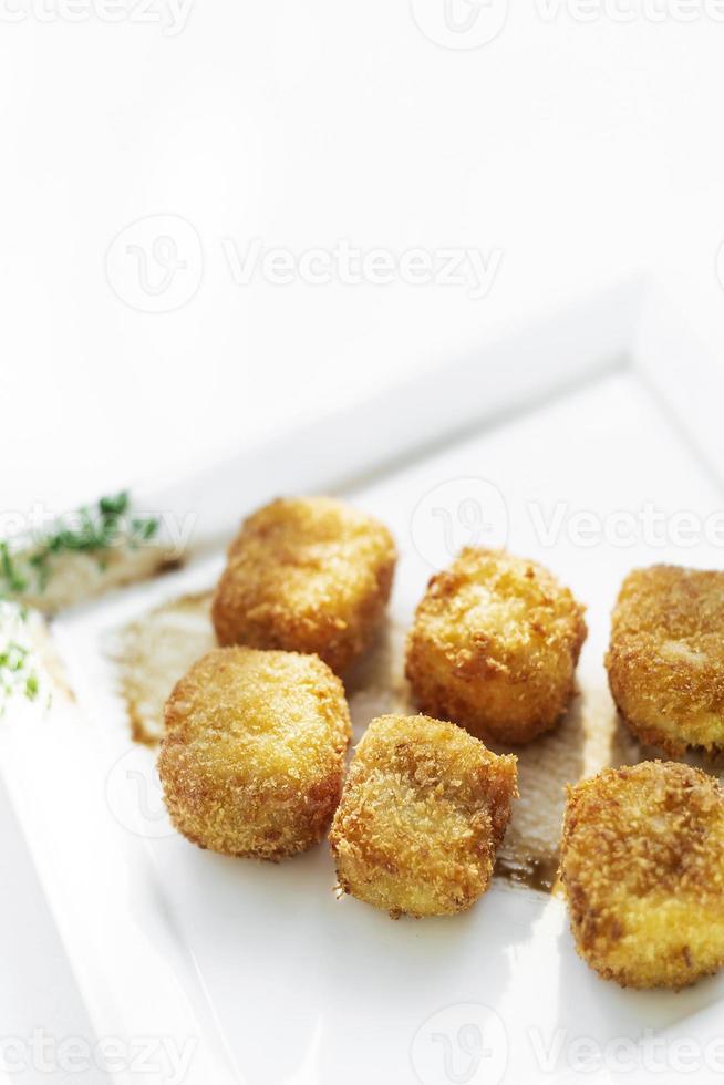 gebratene Kartoffelpüree quadratische Kroketten einfache vegetarische Beilage auf weißem Teller foto