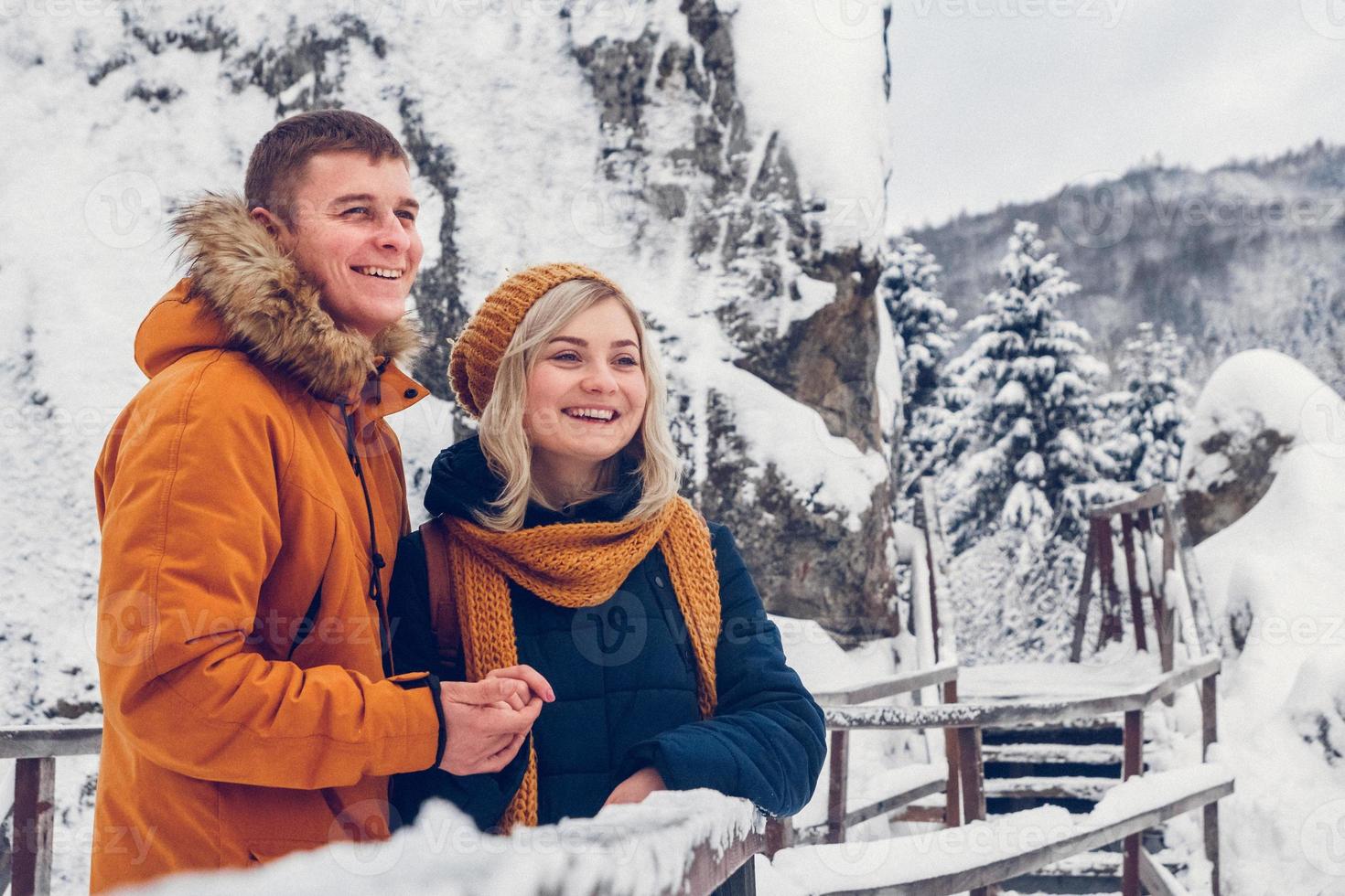 glückliches Liebespaar, das im Winterpark spazieren geht und Schnee genießt foto