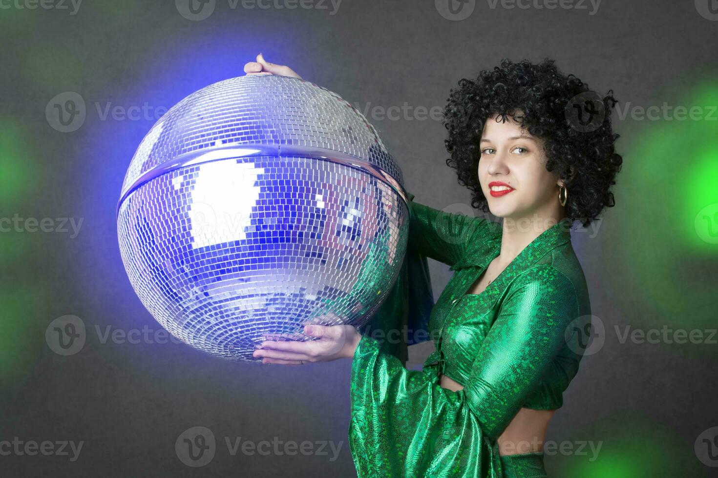 glücklich Disko Stil Mädchen, mit Disko Ball, Halloween Party, auf grau Hintergrund. 80er Jahre thematisch Party. foto