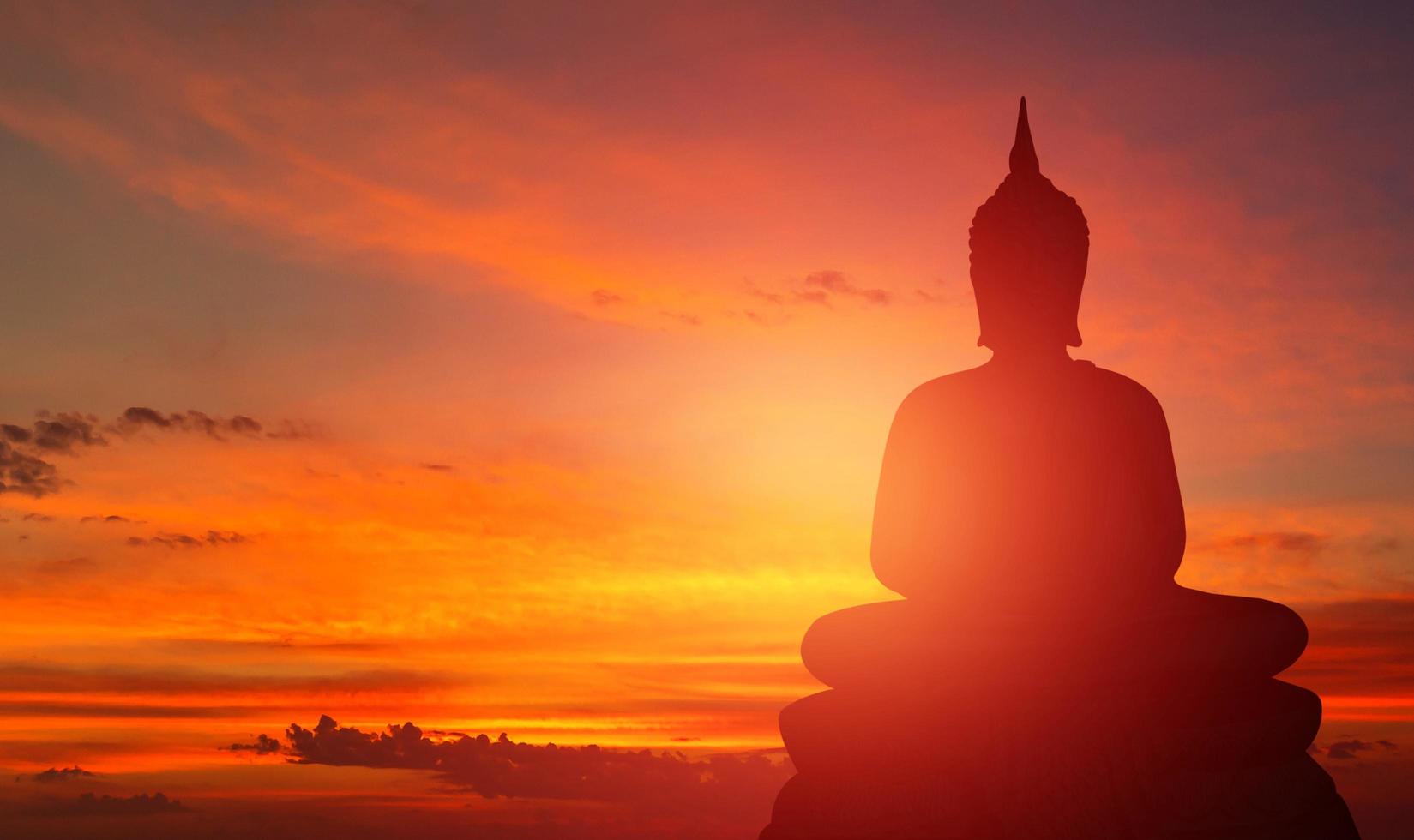 Buddha-Silhouette auf goldenem Sonnenuntergang Hintergrund Überzeugungen des Buddhismus foto