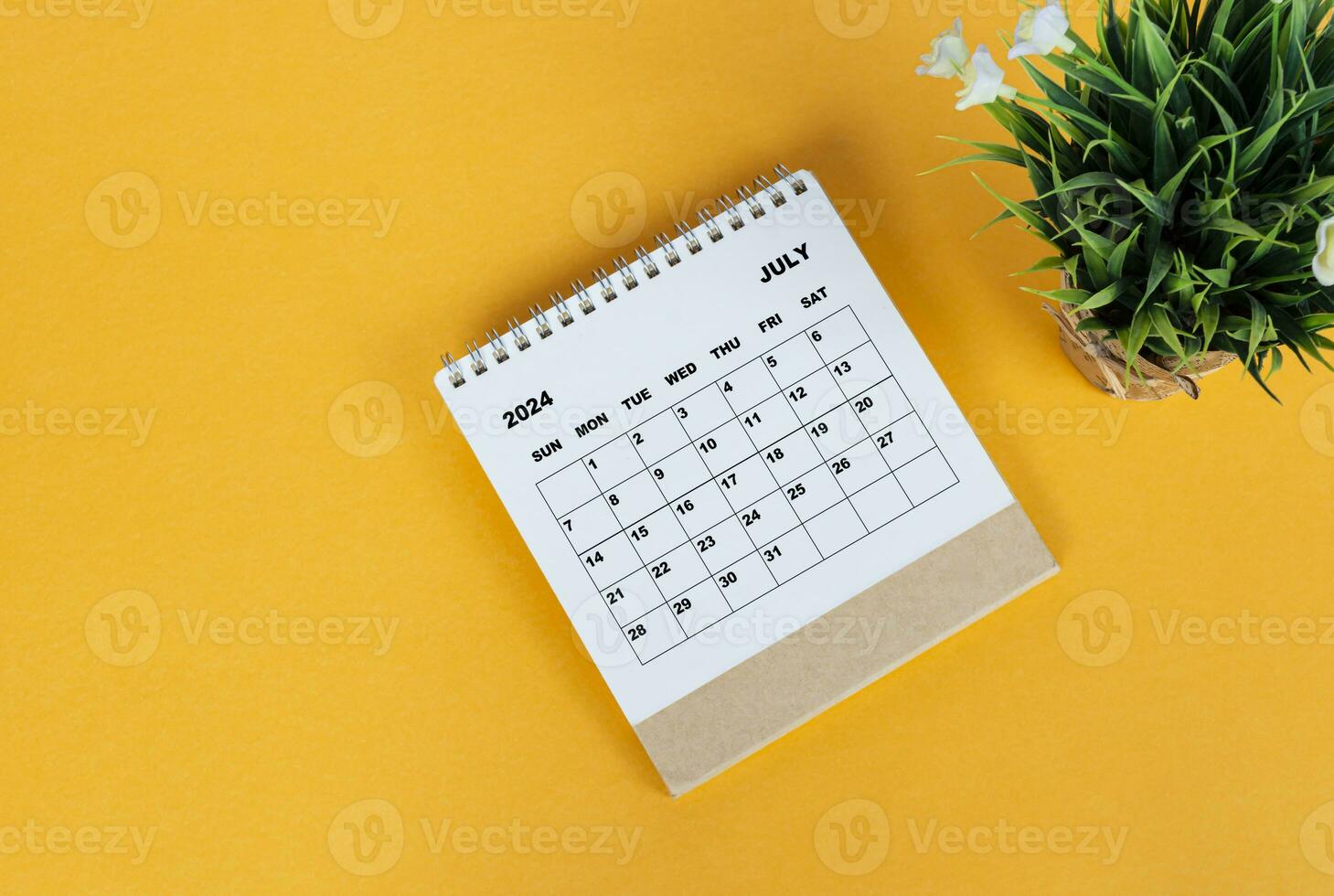 Juli 2024 Schreibtisch Kalender auf Gelb Hintergrund. direkt über. eben legen. foto
