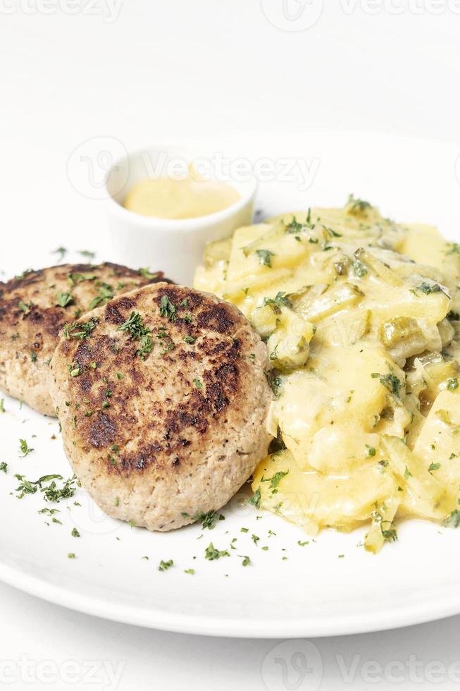 Frikadellen Frikadellen mit cremigen Zwiebeln Bratkartoffeln und Senfsauce auf weißem Teller foto