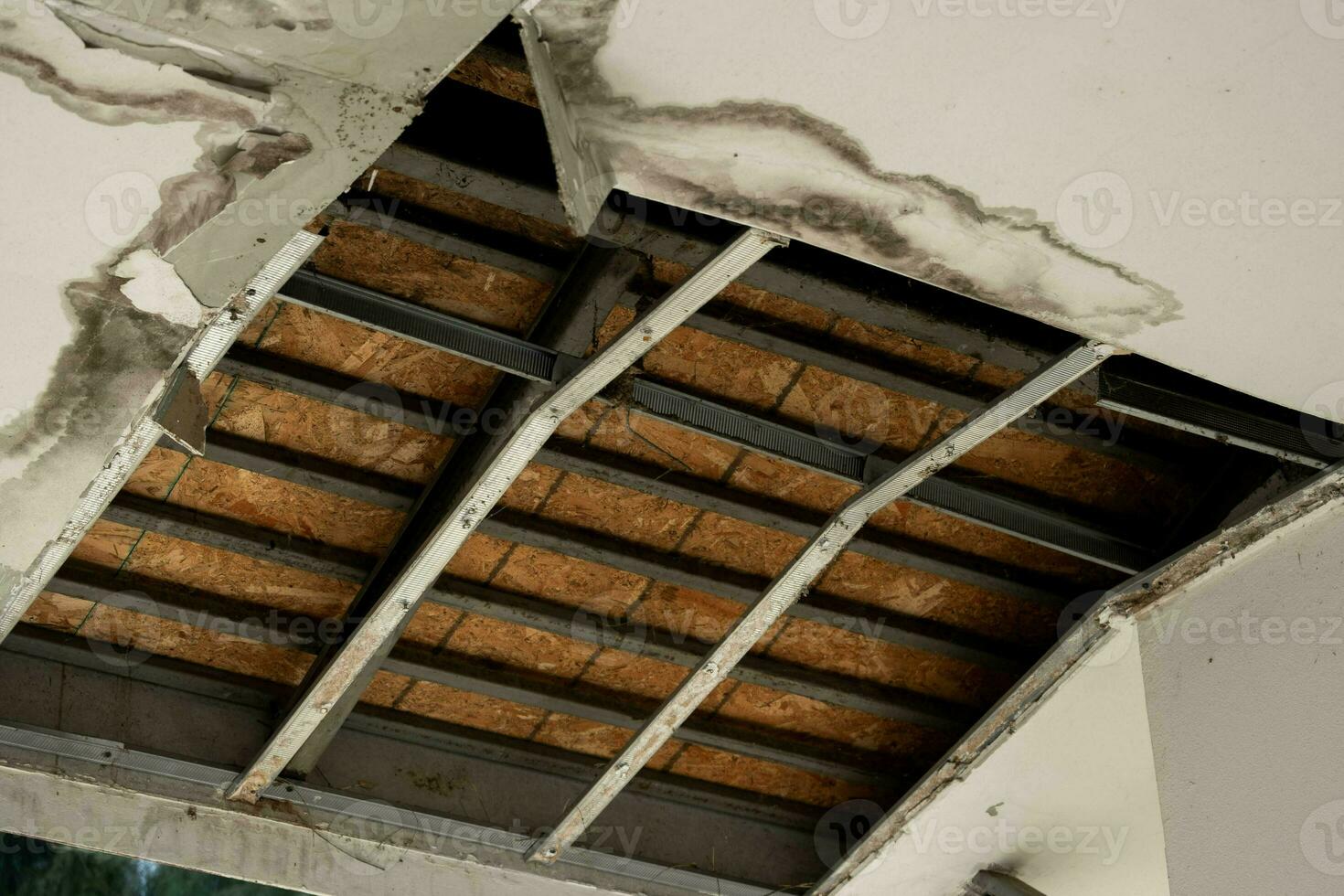 Decke Paneele hätten beschädigt ein groß Loch im das Dach von ein Regenwasser Leck. Decke beschädigt durch Wasser. das Decke Pleite Nieder foto