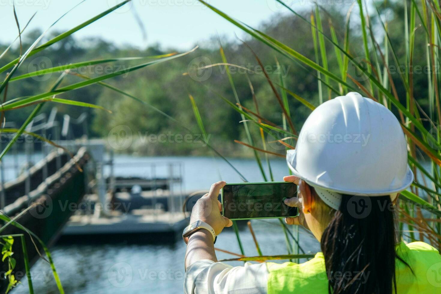 Umwelt Ingenieur Verwendet ein Handy, Mobiltelefon Telefon zu nehmen Bilder und Aufzeichnung Daten Analysieren Sauerstoff Ebenen im das Reservoir. Wasser und Ökologie Konzept. foto