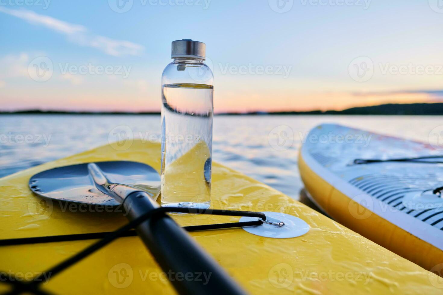 Wasser Flasche auf ein Gelb Paddel Boot. foto