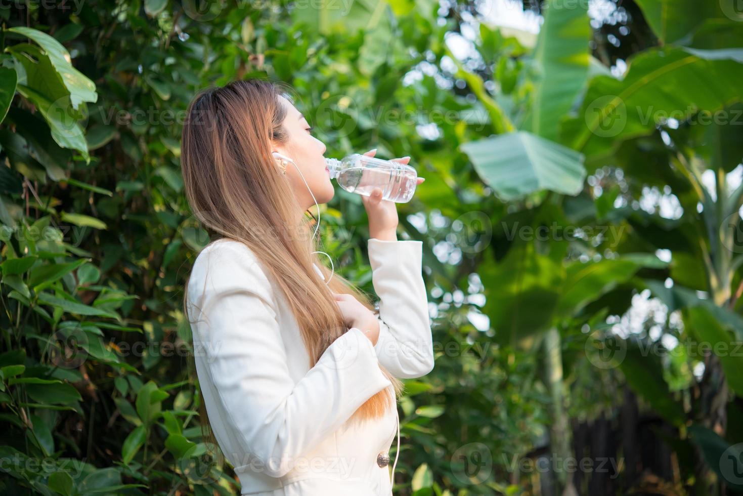 schöne Geschäftsfrau trinkt Wasser nach harter Arbeit foto