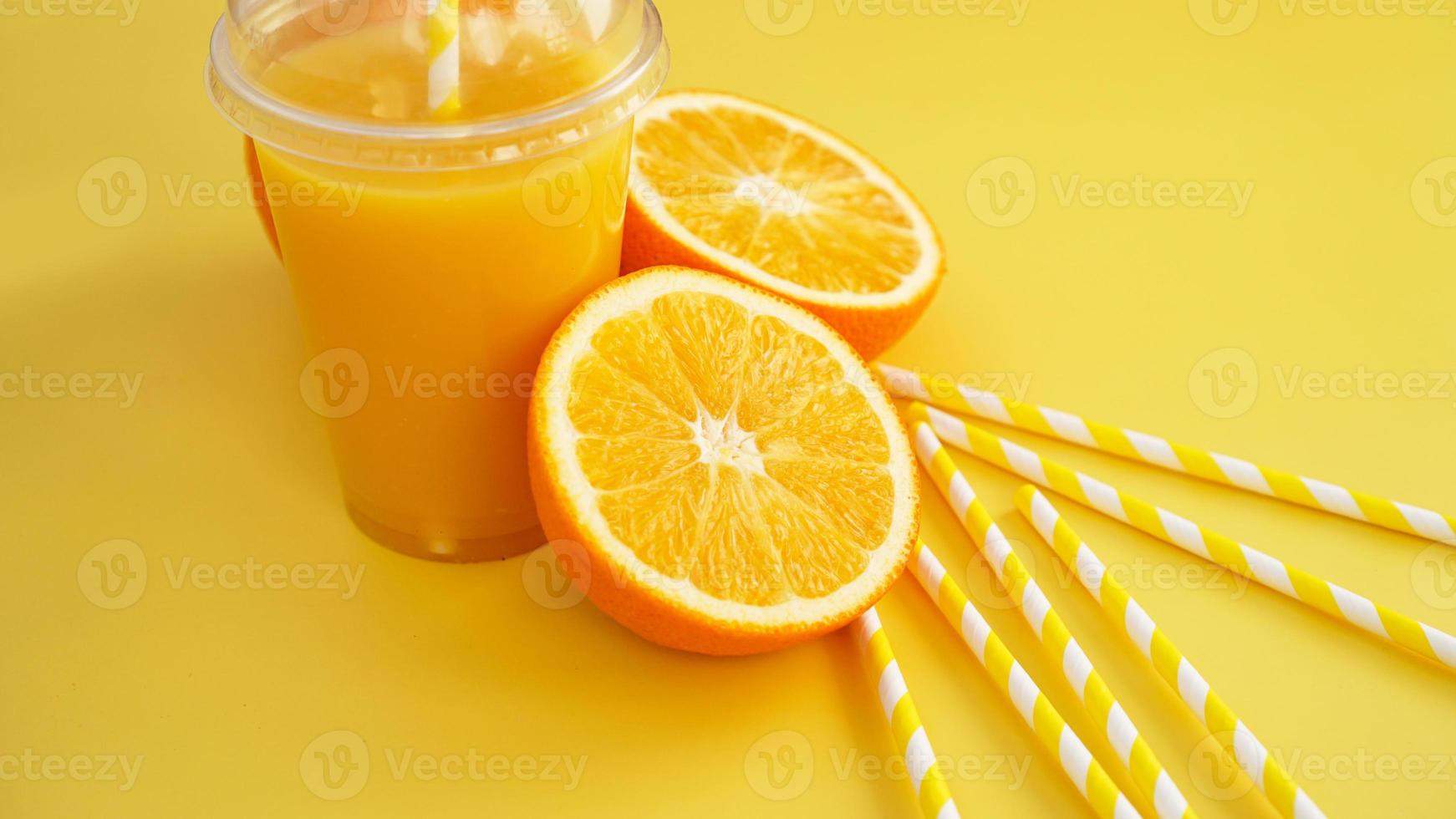 Orangensaft in Fast Food geschlossene Tasse mit Tube auf gelbem Hintergrund foto