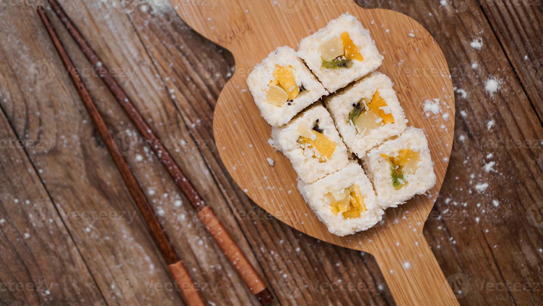 Sushi-Lieferung. süße Brötchen aus Reis, Ananas, Kiwi und Mango. foto