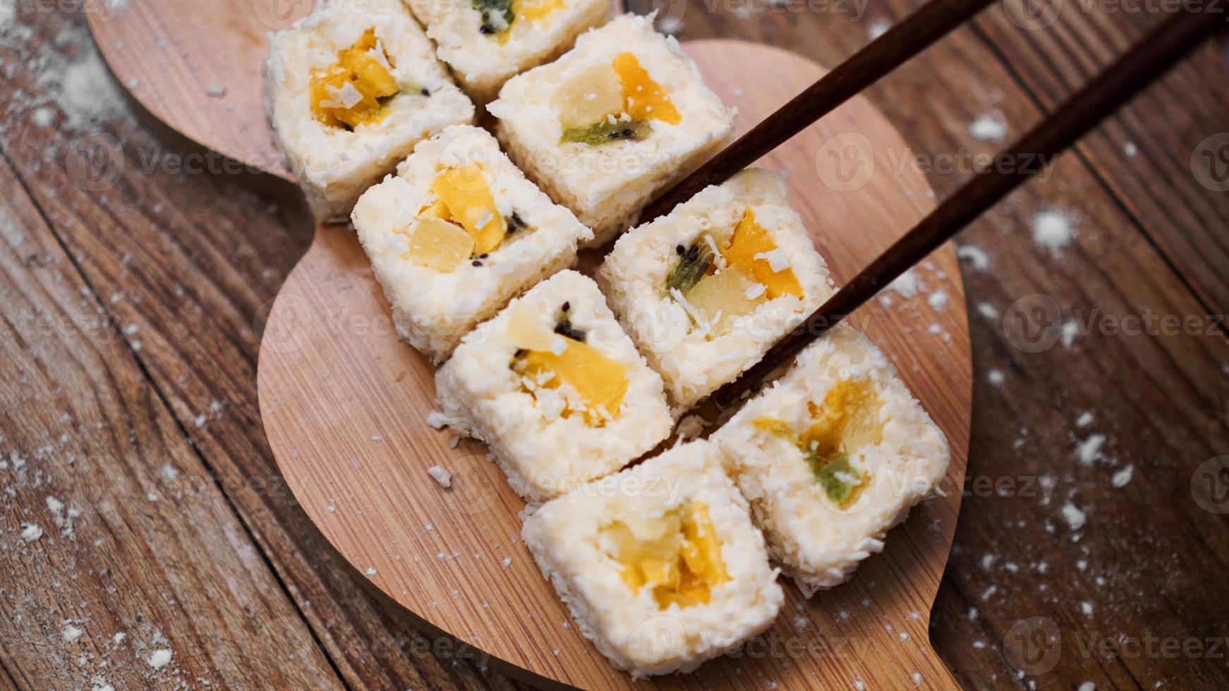 Sushi-Lieferung. süße Brötchen aus Reis, Ananas, Kiwi und Mango. foto