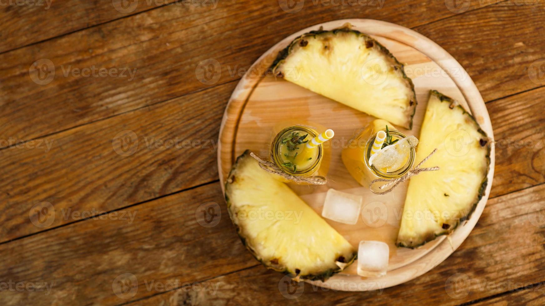 frischer Ananassaft mit Eis in einer kleinen Glasflasche foto