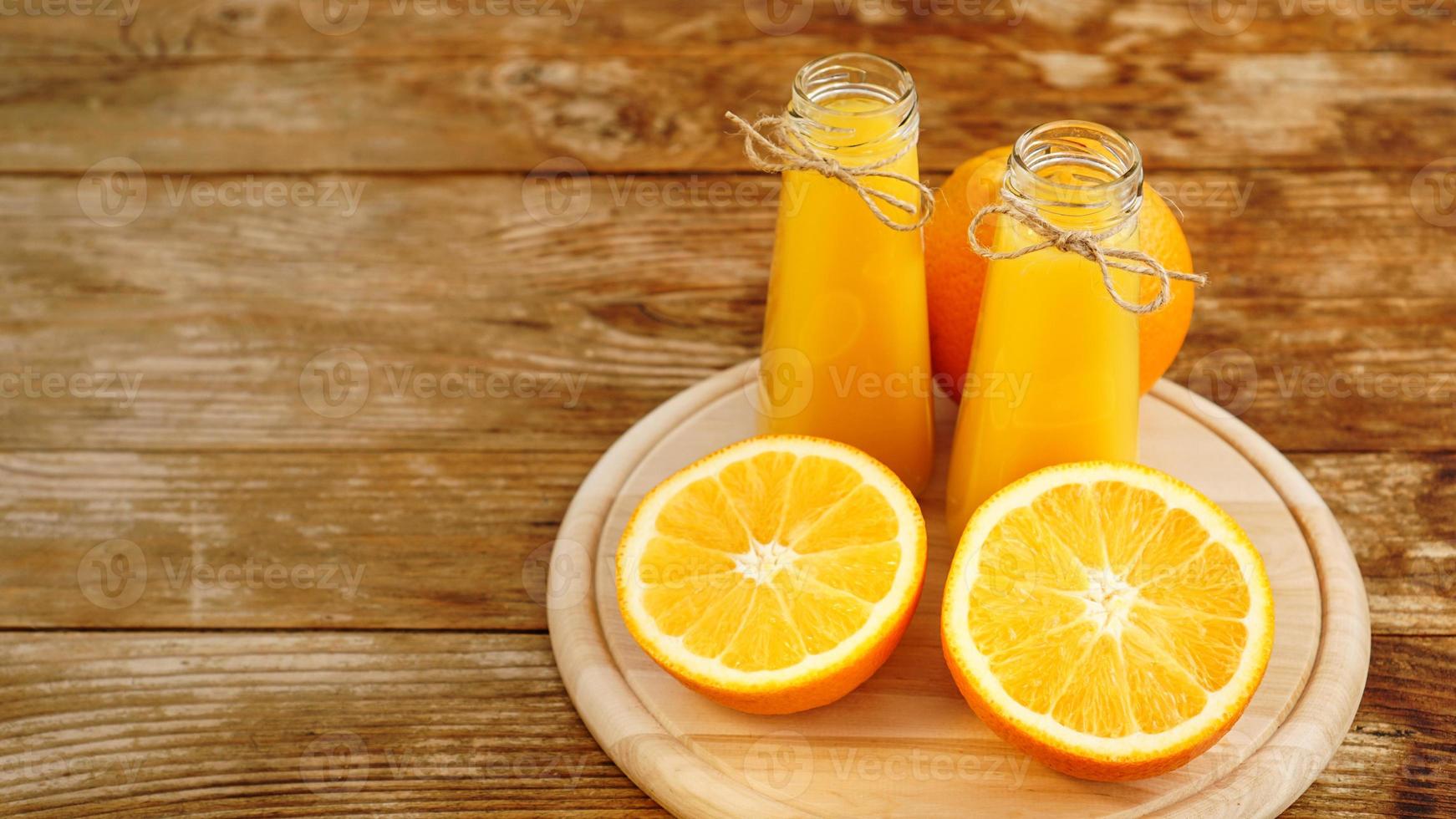 frischer Orangensaft auf Holztisch auf einem Holzbrett foto