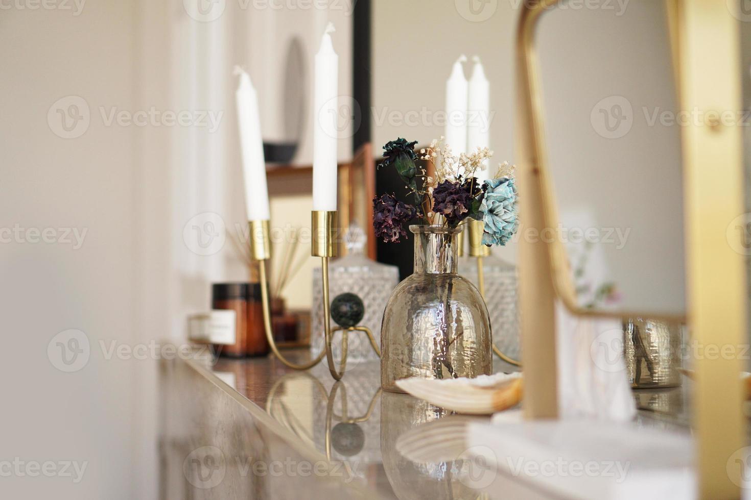 Inneneinrichtung zu Hause. Glas mit getrockneten Blumen, Vase und Kerze foto
