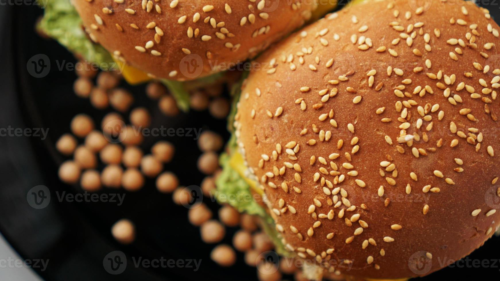 Gemüseburger mit Kichererbsenschnitzel. zwei Burger auf schwarzem Teller foto