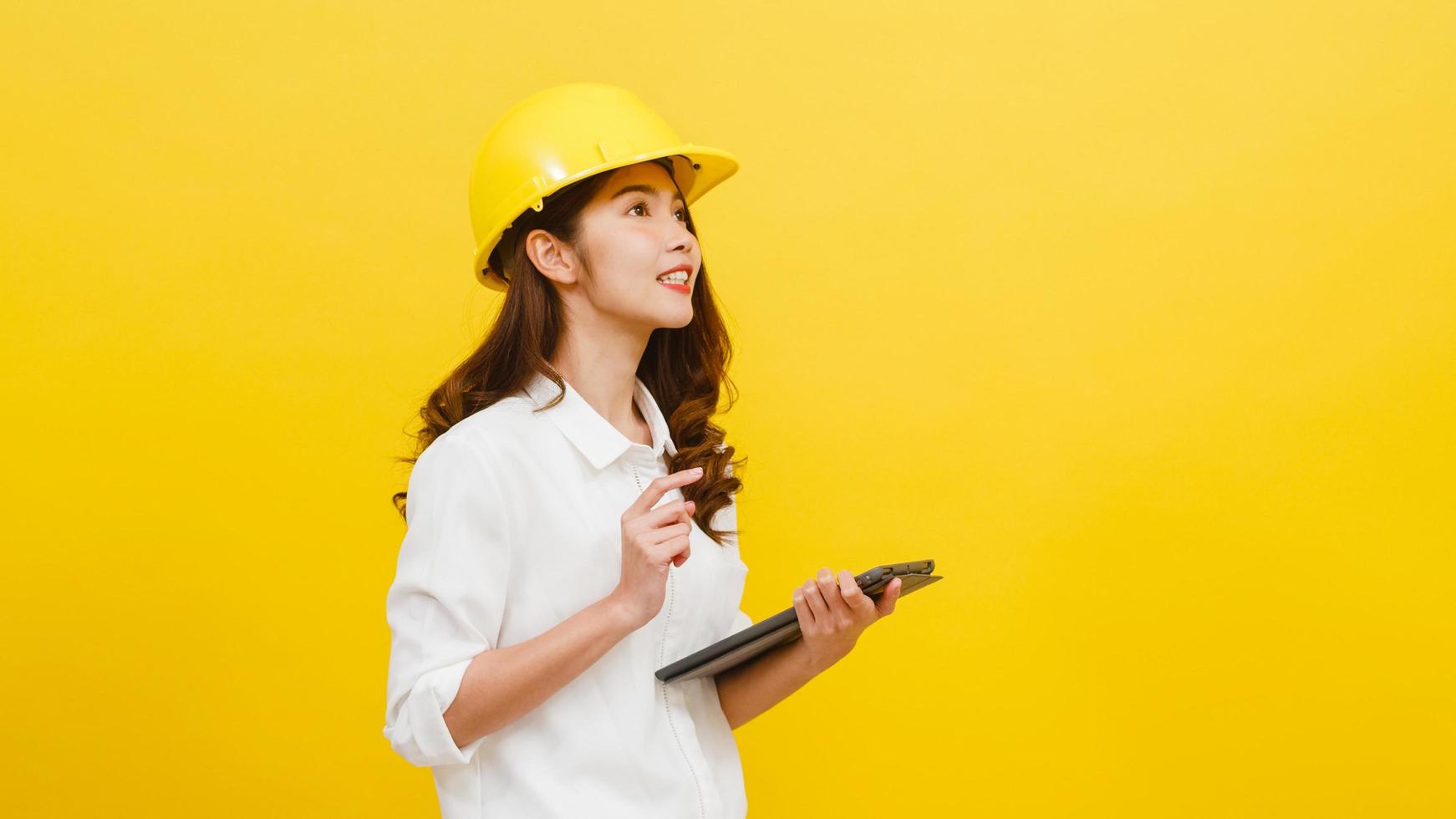 asiatische Frau Ingenieur mit digital-Tablette auf gelbem Hintergrund. foto