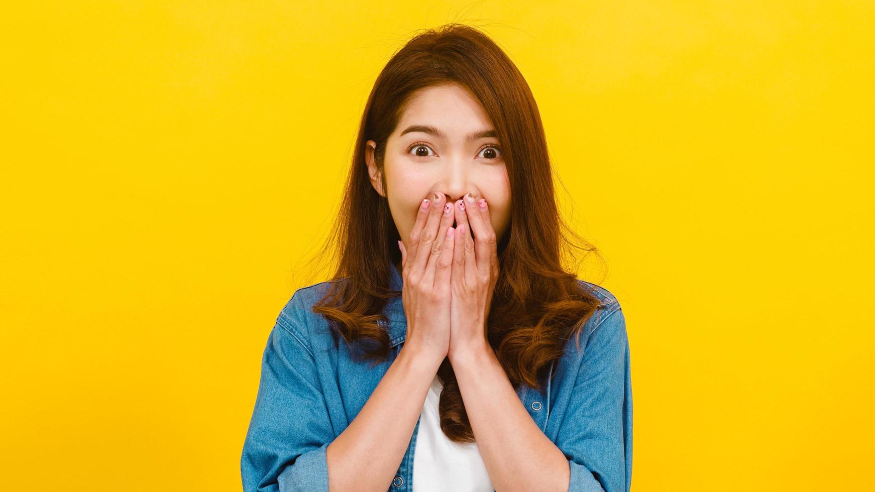 asiatische frau mit positivem ausdruck auf gelbem hintergrund. foto