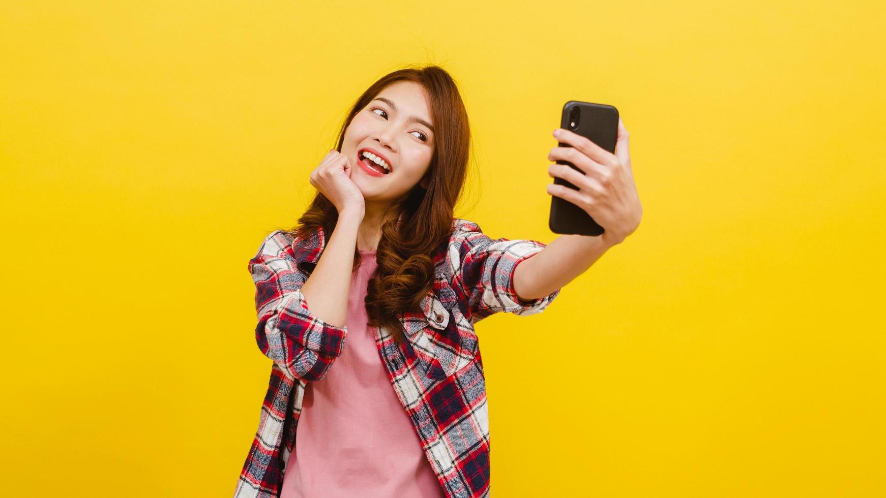 asiatische frau, die selfie foto am telefon mit positivem ausdruck macht.