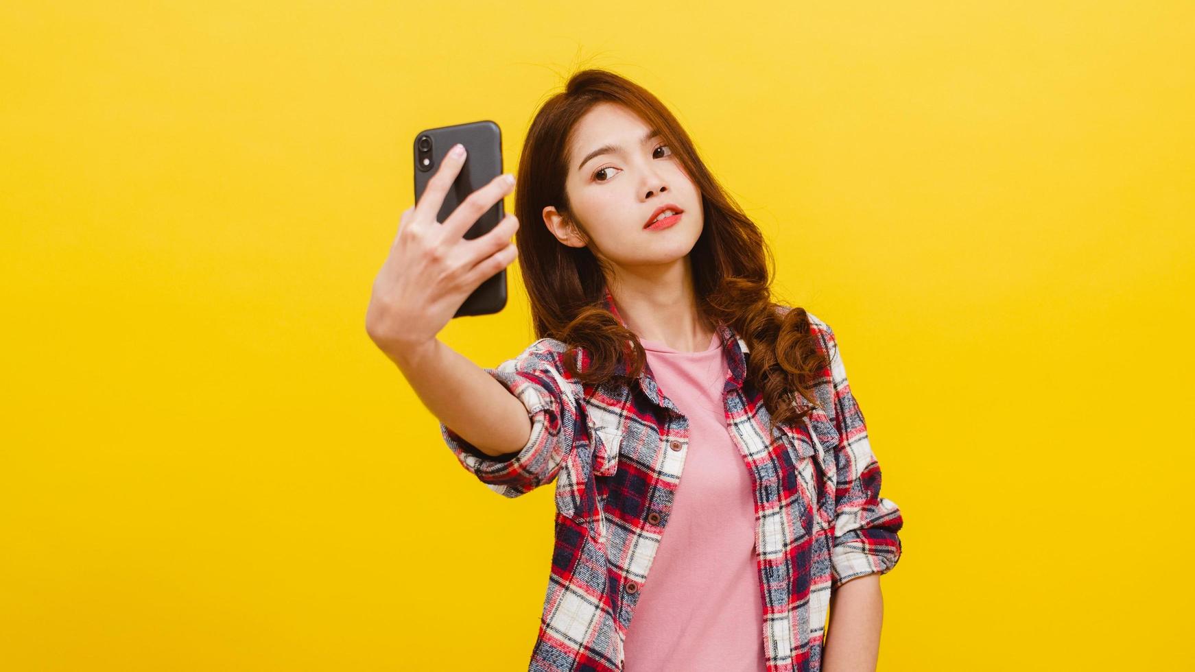 asiatische frau, die selfie foto am telefon mit positivem ausdruck macht.