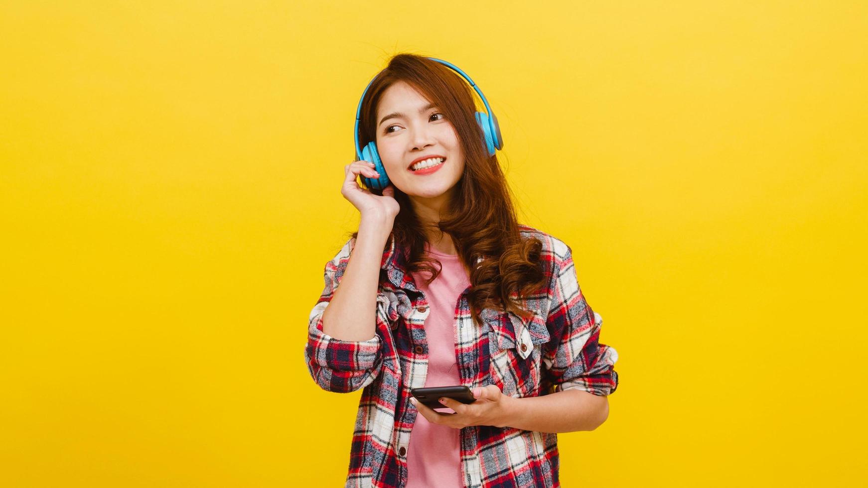 asiatische Dame mit Kopfhörern, die Musik vom Smartphone hört. foto