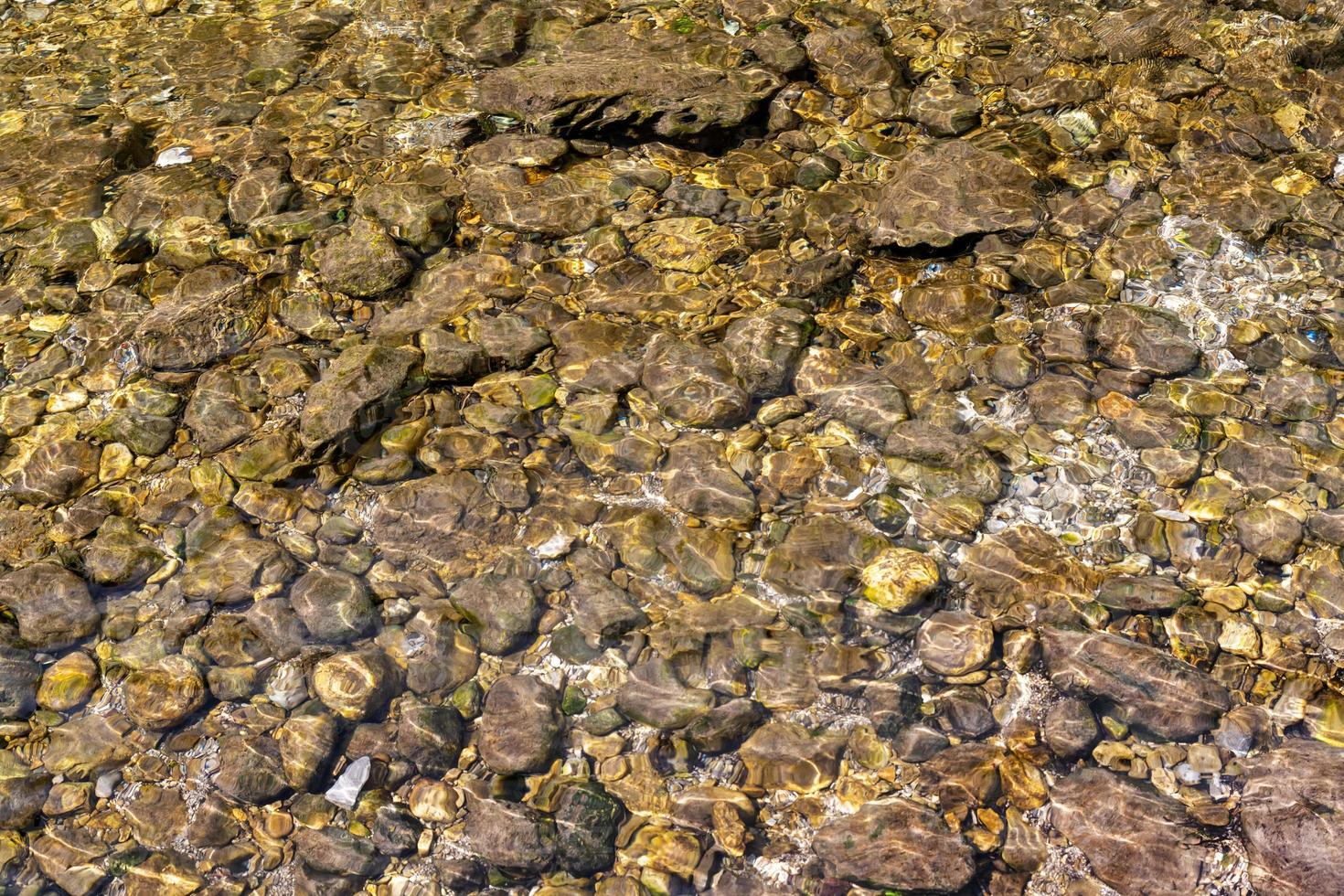 Kieselsteine unter der Wasseroberfläche eines Baches als Hintergrund foto