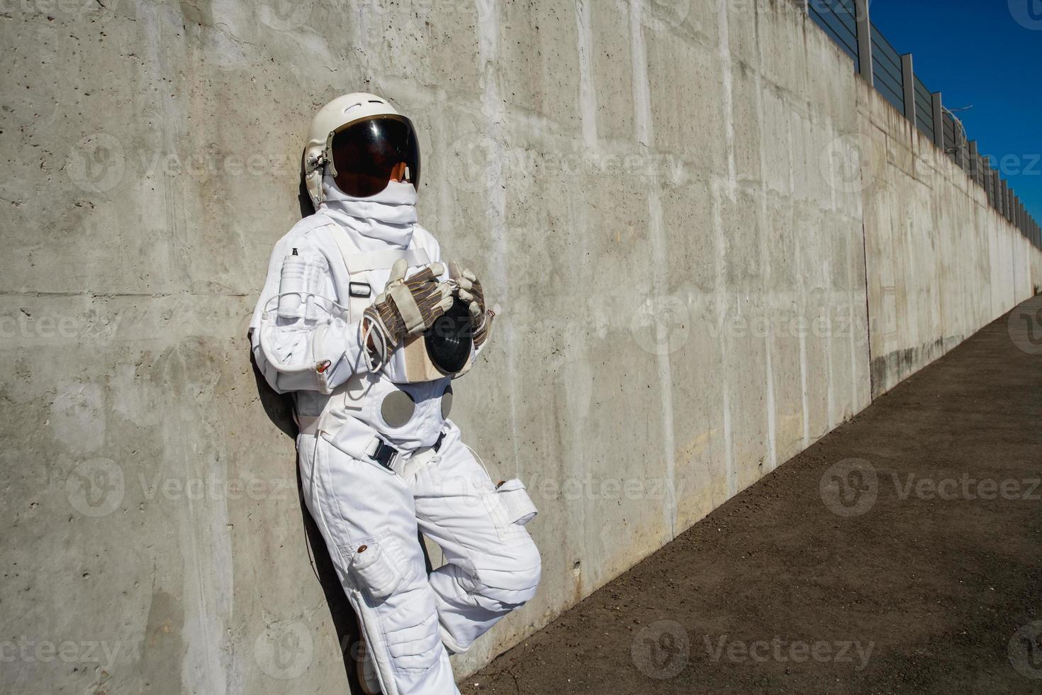 Astronautin ohne Helm auf dem Hintergrund einer grauen Wand foto