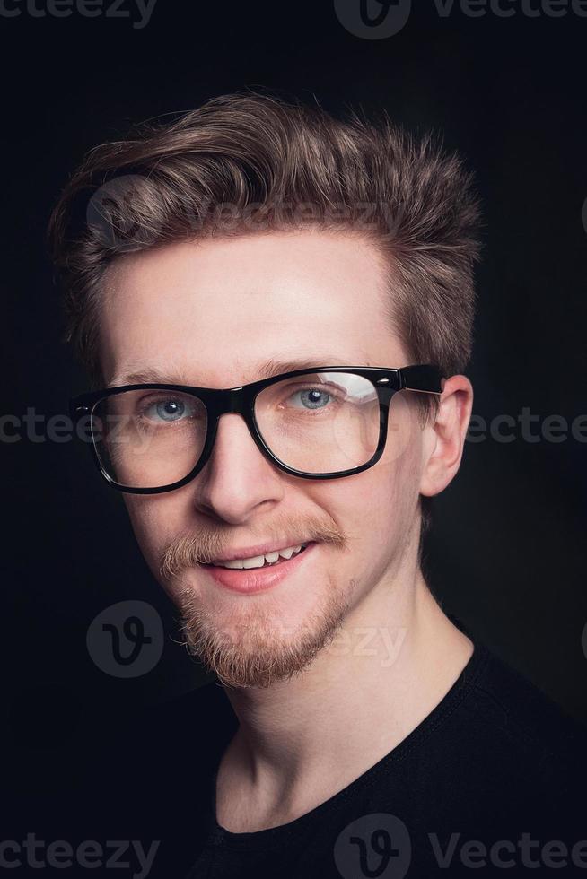 Porträtmann mit Brille auf schwarzem Hintergrund foto