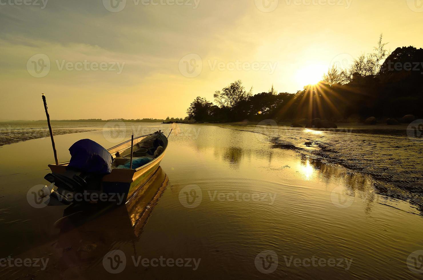Boot in Strandnähe, wenn die Sonne untergeht foto