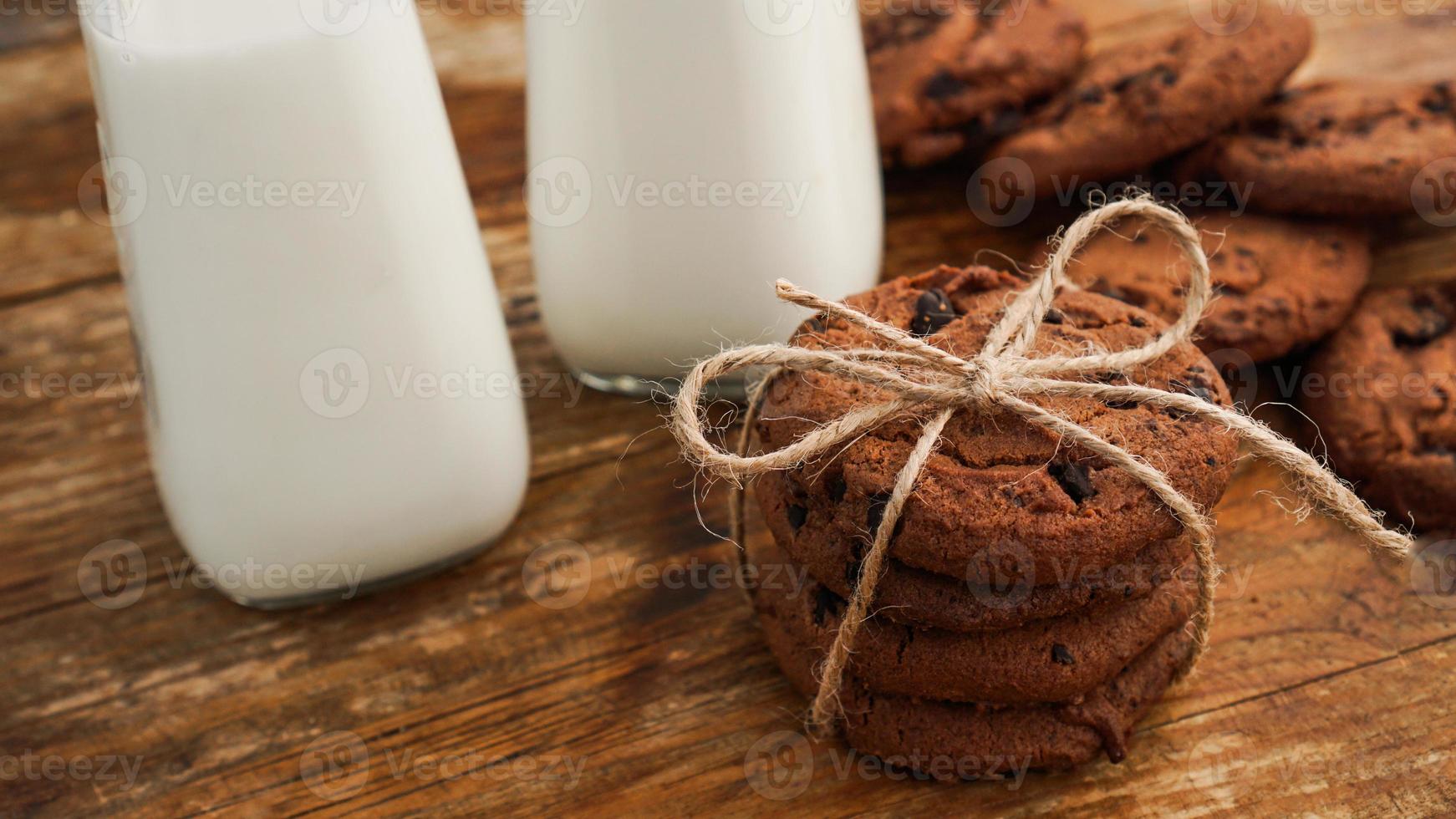 Schokoladenkeks mit Milch auf Holztisch. hausgemachte Kekse. foto