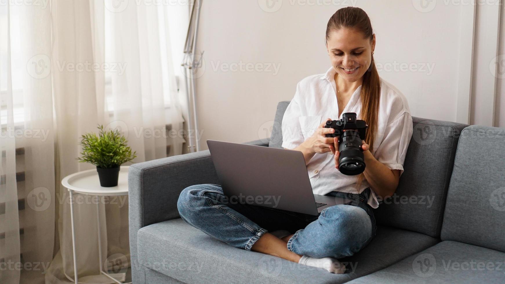 glückliche junge Frau mit Fotokamera mit Laptop zu Hause foto