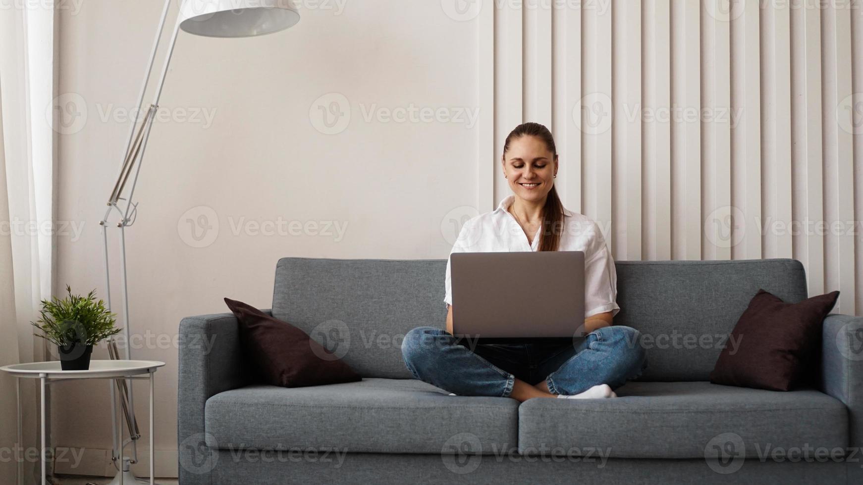 Frau, die von zu Hause oder vom Studenten am Laptop arbeitet foto