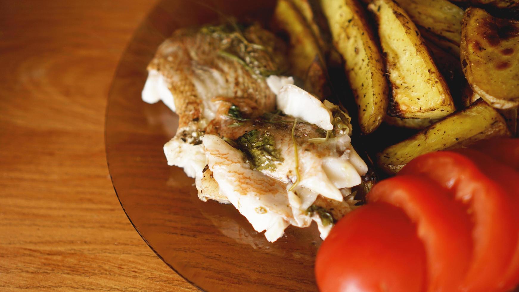 Fischgericht - gebratenes Fischfilet mit Bratkartoffeln und Gemüse foto