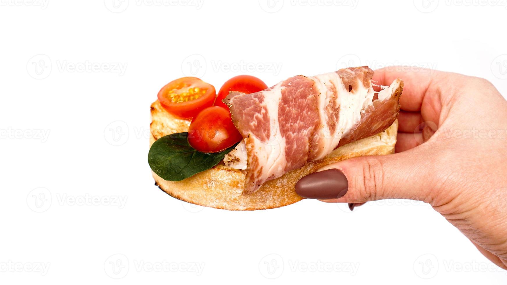 Bruschetta auf Ciabatta in der Hand auf einem Weißen foto