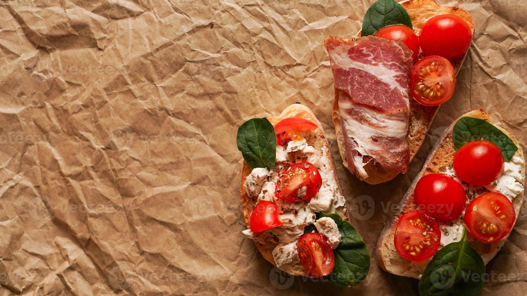 drei frische Bruschetta auf Kraftpapier. leckerer Snack foto