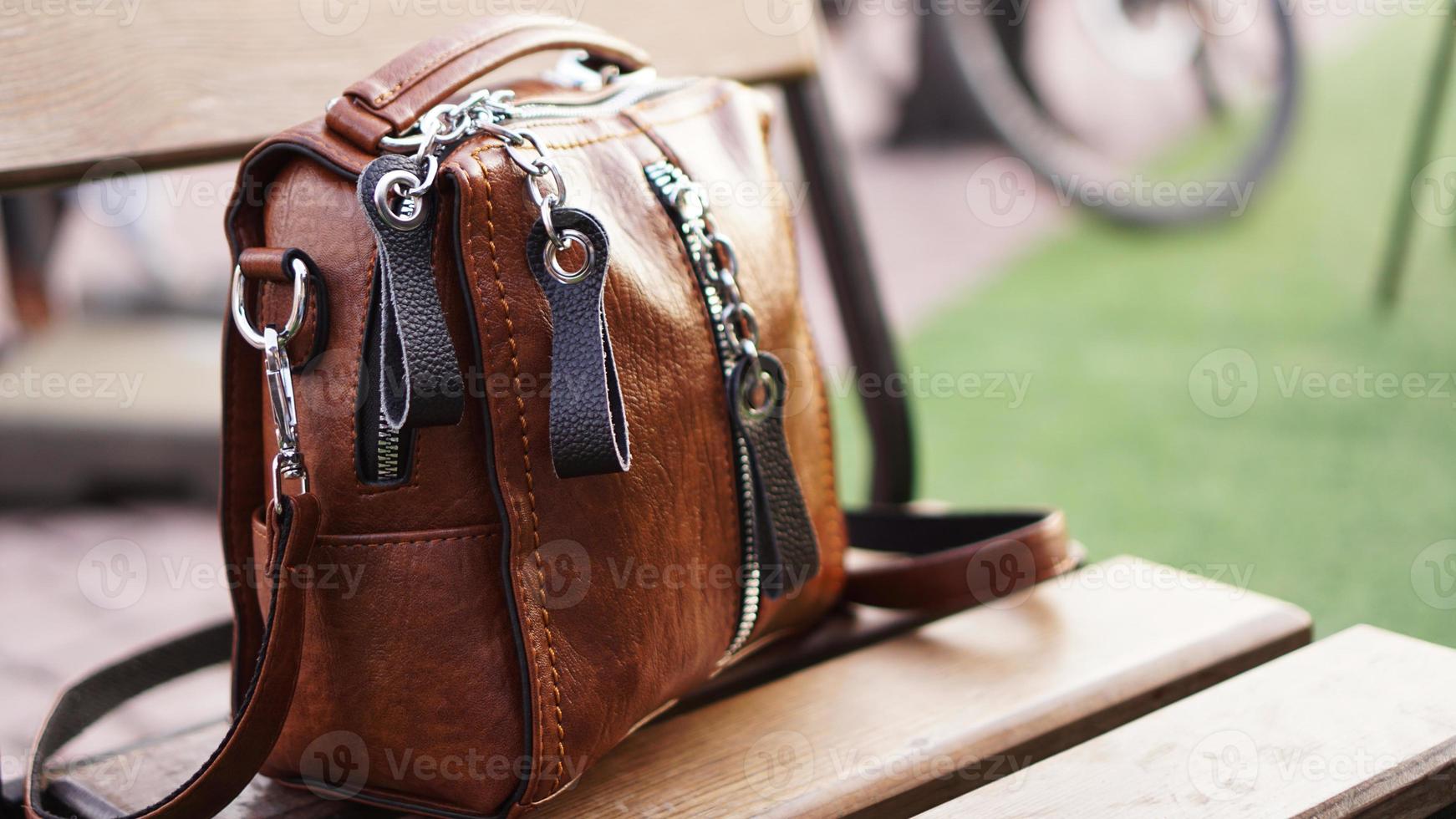 braune Ledertasche außen. verschwommener Sommerhintergrund foto