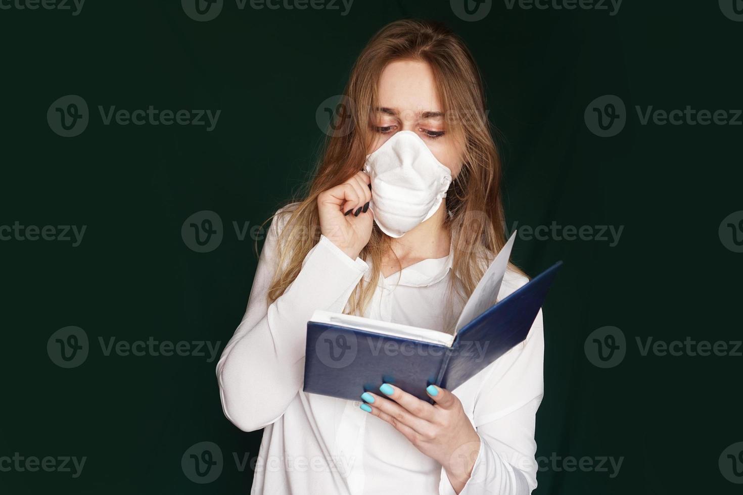 junges Mädchen in einer medizinischen Maske in einer weißen Bürobluse foto