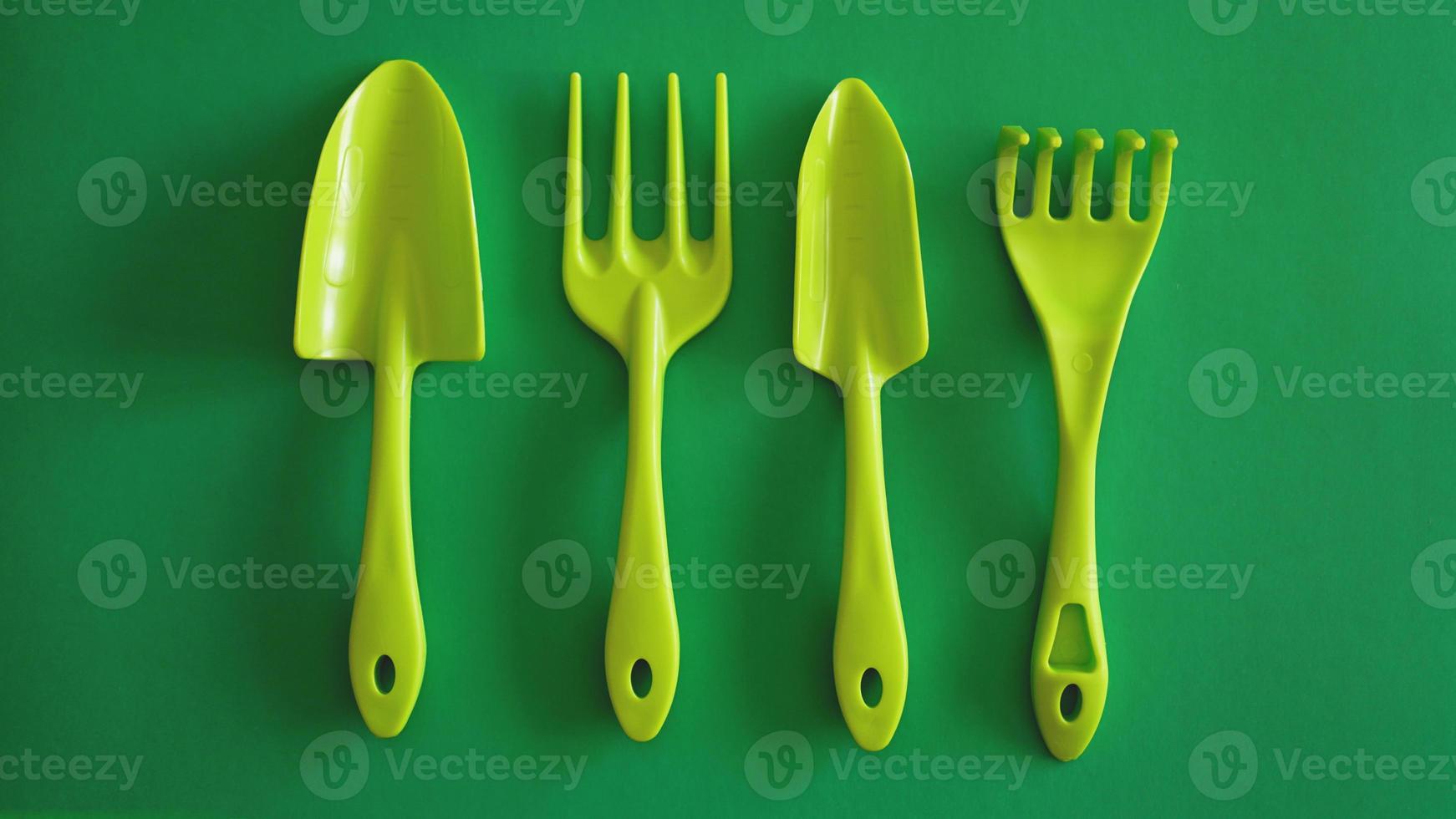 Satz grüne Gartengeräte auf grünem Hintergrund foto